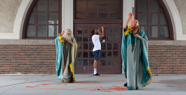 Performance still with three performers.