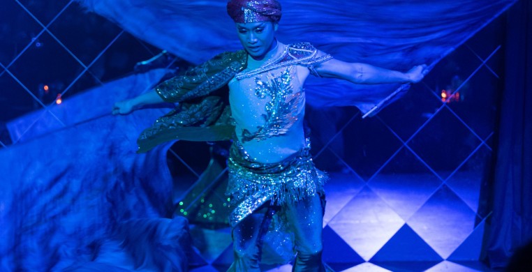 Asian American male bellydancer spinning in a merman costume