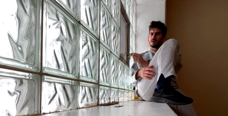 Still of Rigoberto Fernandez Saura sitting on his windowsill in “Home: A Place Within.” Photo courtesy of Hedwig Dances