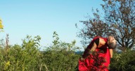 woman dressed in red fabric arching in Nature